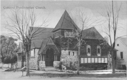 Black and white image of small church building with stone wood siding