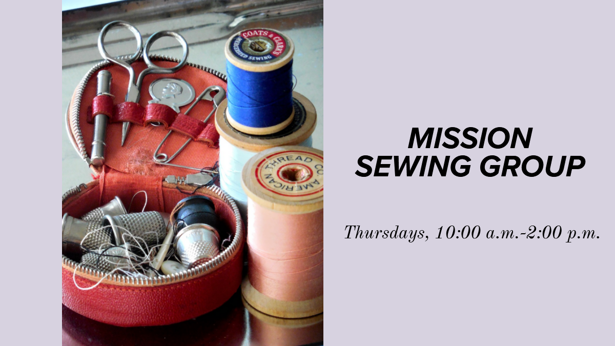 an open basket of sewing notions such as scissors and buttons next to a couple of spools of thread