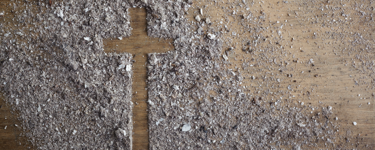 the outline of a cross in ashes on a table