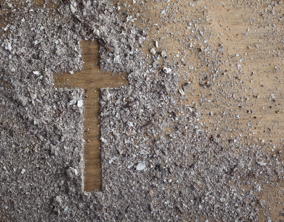 the outline of a cross in ashes on a table