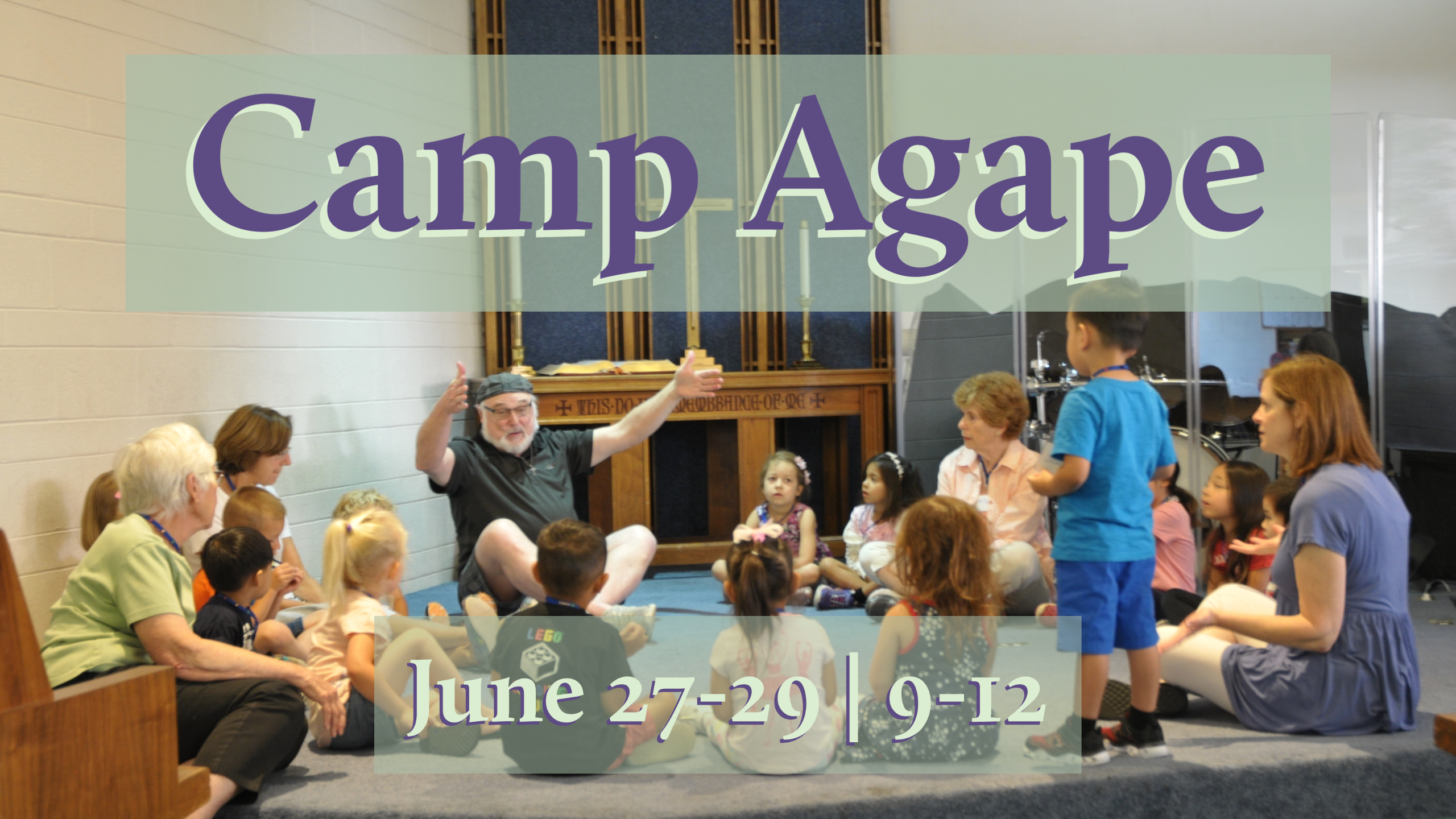 photo of children and adults sitting in a circle on the floor in the chapel with the text "Camp Agape June 27-29 | 9-12"